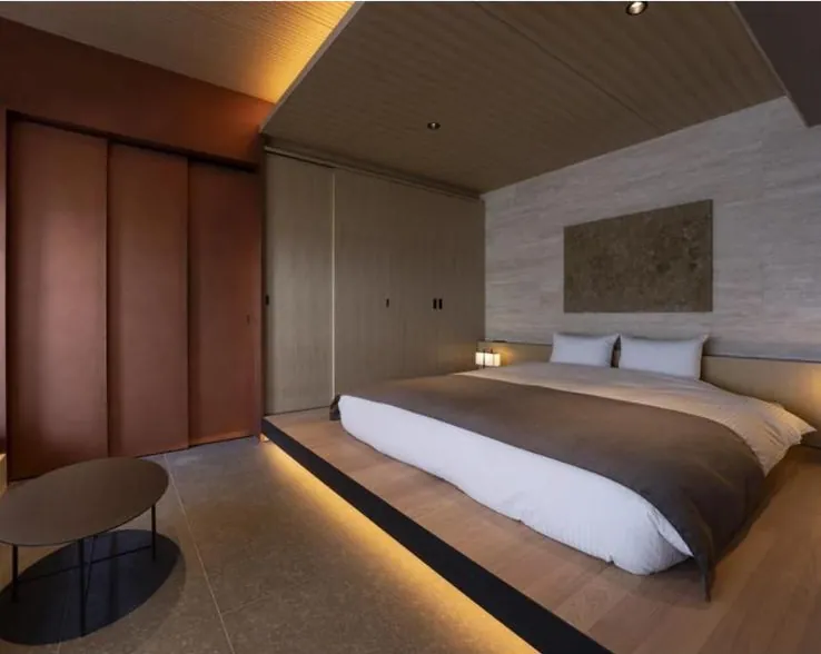 Hotel-style bedroom with platform bed and warm cove lighting